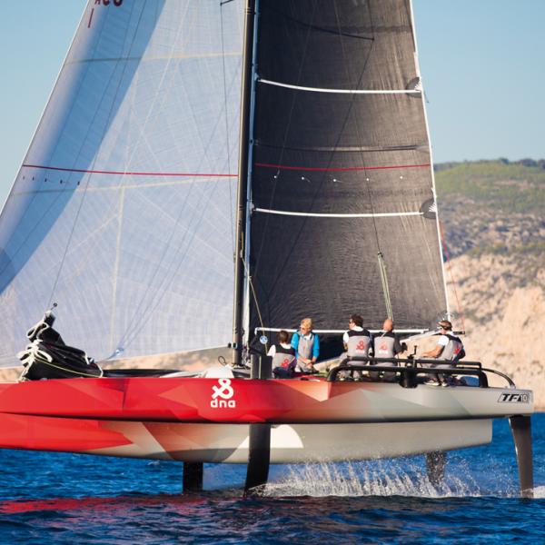 The crew (4 or 5 members) in flight configuration: A helmsman, a mainsail trimmer, a headsail trimmer and a grinder in the central hull 
