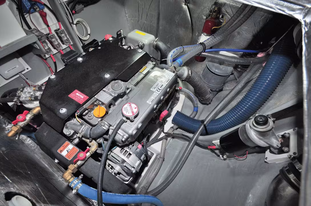 A very apt and carefully-designed engine installation, well forward in the boat to give better centering of weight as well as better protection for the motors against spray (inevitable with deck hatches!).  Seen here with the access panel open beneath the
