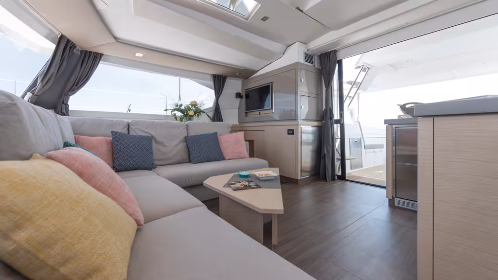 The deck saloon opens wide onto the cockpit. The upholstery has been redesigned. Note the portlights in the coachroof ceiling which allow a direct view of the set of the sails from inside 