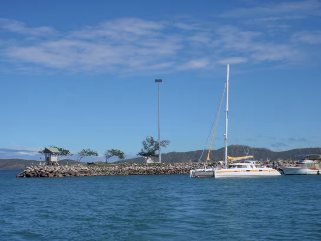 Jangada on her mini pontoon in the protected harbor (check out the watch tower to the left) of the Royal Papuan Yacht Club in Port Moresby (PNG)…  