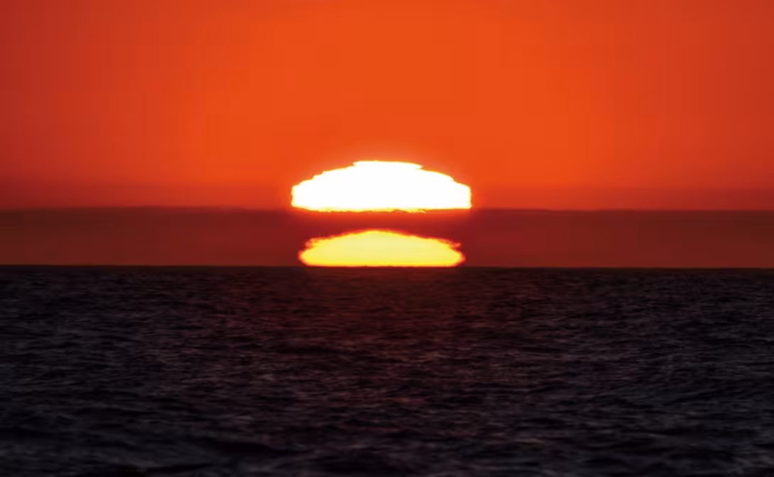 Spectacular mirage of a sunset; the sun climbs upwards to set above the water…upside down!